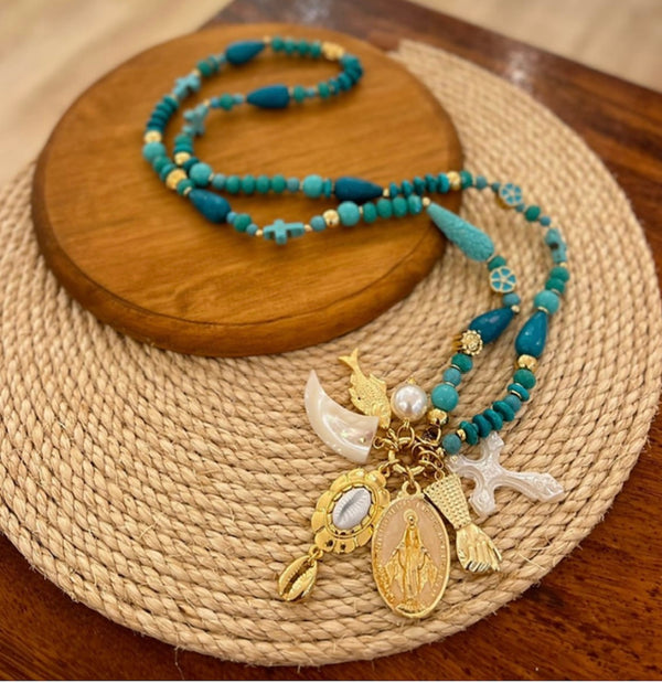 Long turquoise necklace with gold and mother of pearl charms